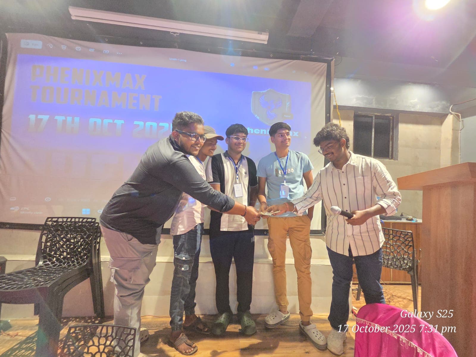 PHENIXMAX tournament participants celebrate together on stage.